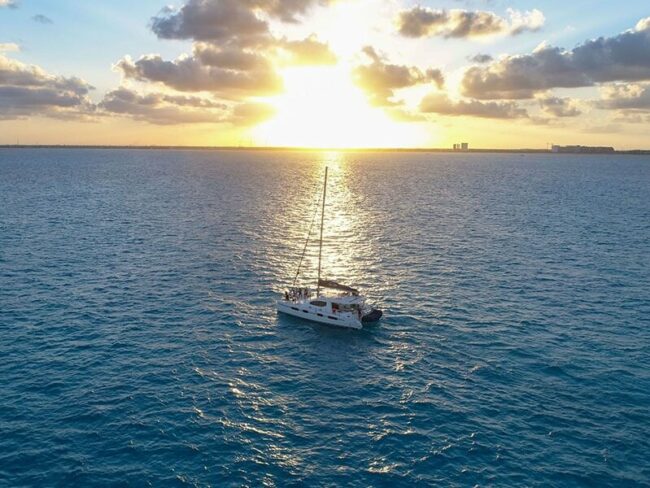 Watch the sunset settle on the edge of the sea while chilling on board with your favourite songs in our half day sail cat