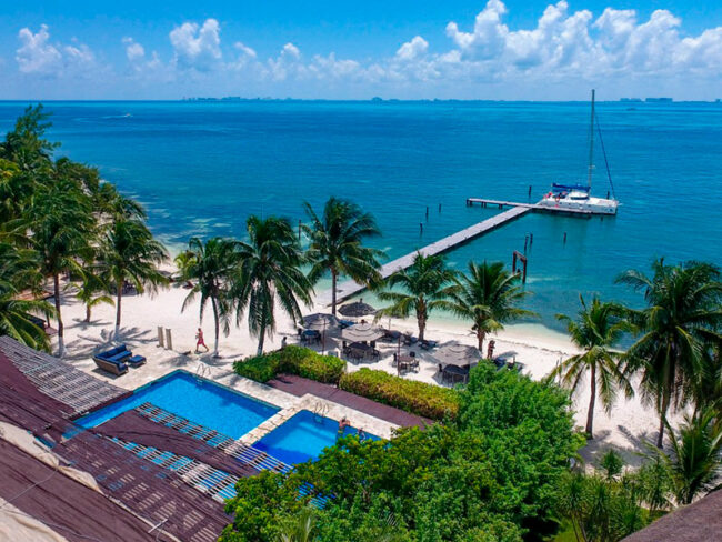 Swim in the pool and enjoy a super nice meal here at the beach club surrounded by palm trees in our luxurious catamaran to Isla Mujeres Tour