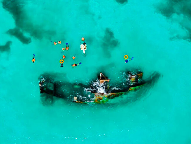 Snorkel in crystal clear waters and explore the sunken ship at the half day Private catamaran 45 guests to Isla Mujeres