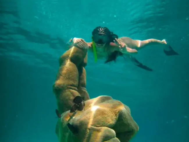 Take a picture with the underwater statues at El Meco Reef, the best snorkelling spot, while sailing on our Full Day Private Sail Cat 30 Guests to Isla Mujeres