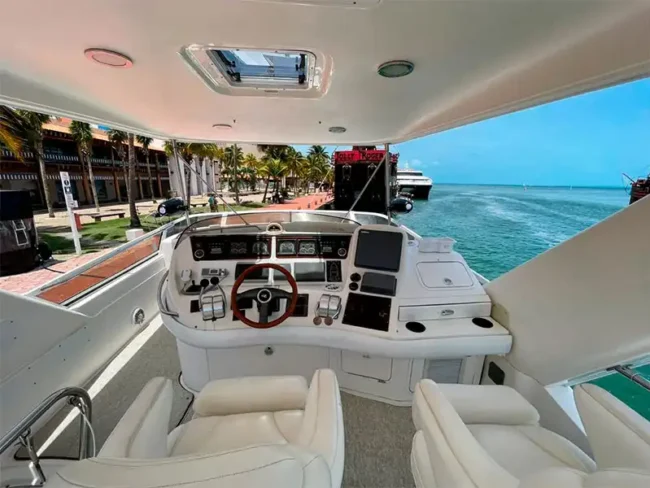 Helm with two comfortable white seats with shade on the top floor of the Private Yacht for 20 People / Cancun