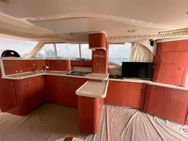 Private Yacht for 20 People in Cancun / living room in the yacht's cabin with plenty of space, a tv, a kitchen, bluetooth speakers, and plenty of comfy seats